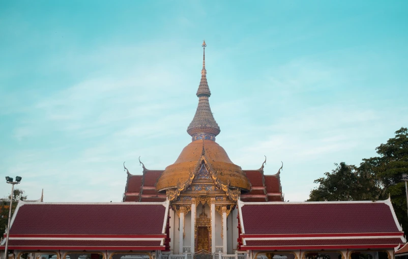 a very tall church with red roof and a sky background