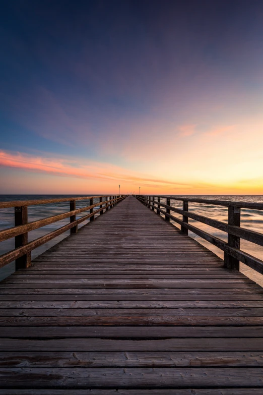 a pier with a wooden path that stretches out into the ocean