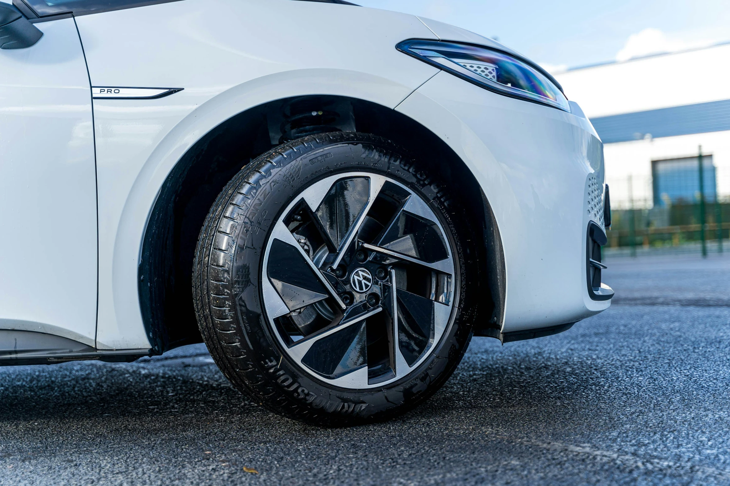 the front wheel of a white car on a road