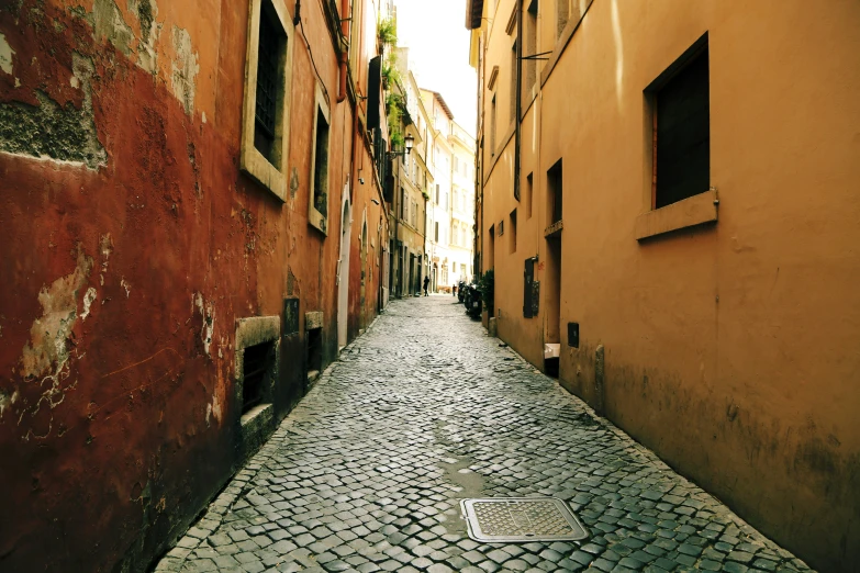 an alley way with a fire hydrant near brick buildings