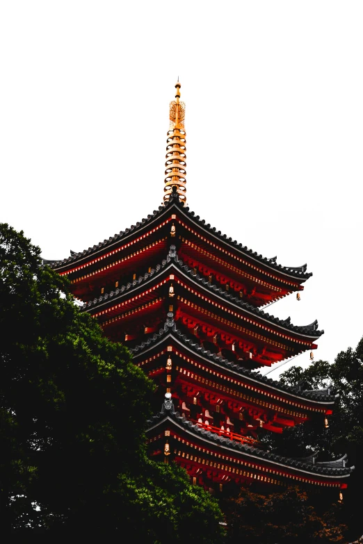 a red pagoda stands high in the sky above a forest