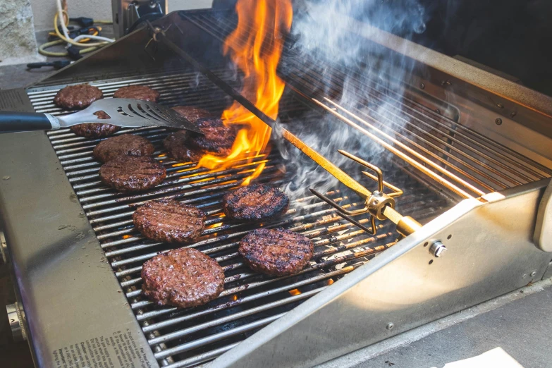 some hamburgers are being cooked on the grill