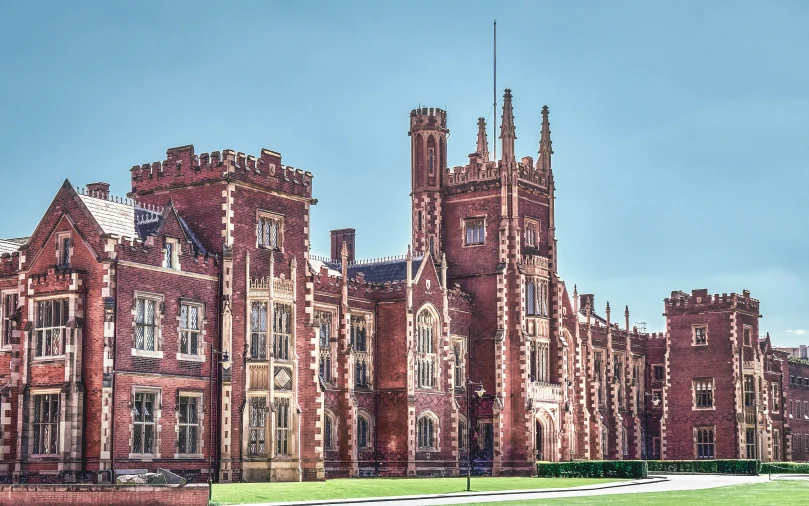 large old brick building standing on top of grass field