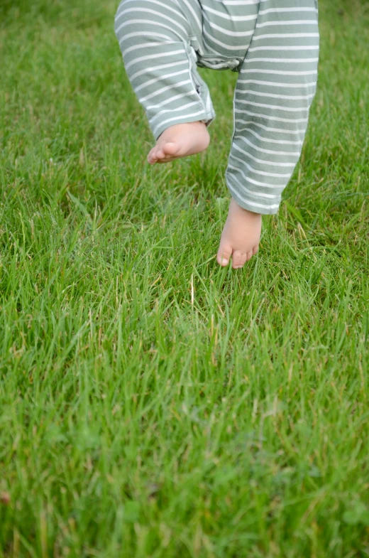 a young child is standing in the grass