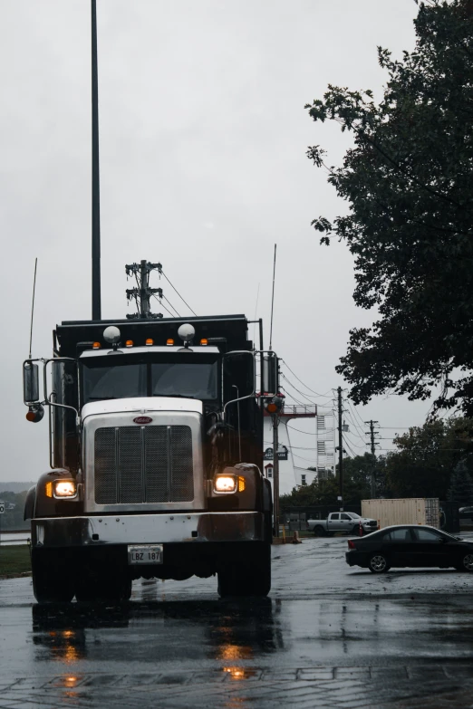 the back of an eighteen wheeler truck traveling through a rain soaked street