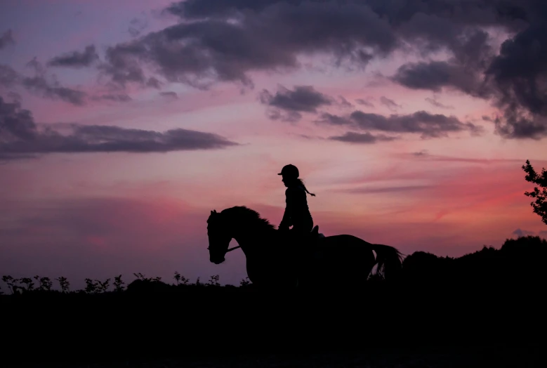 a man that is riding a horse in the dark