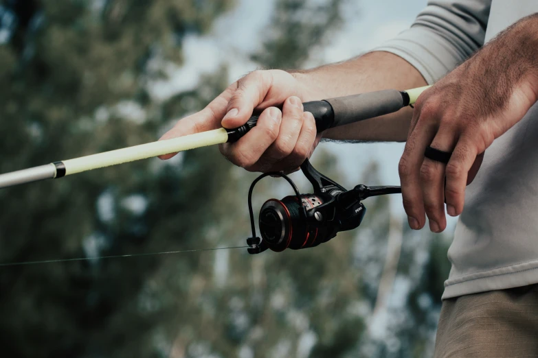 a man holding onto an extended fishing rod and reel