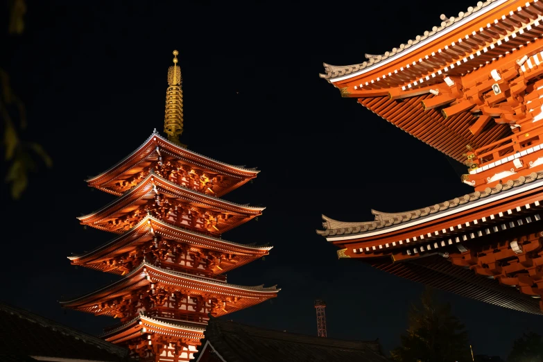 some tall brown and white tower with a lit up sky in background