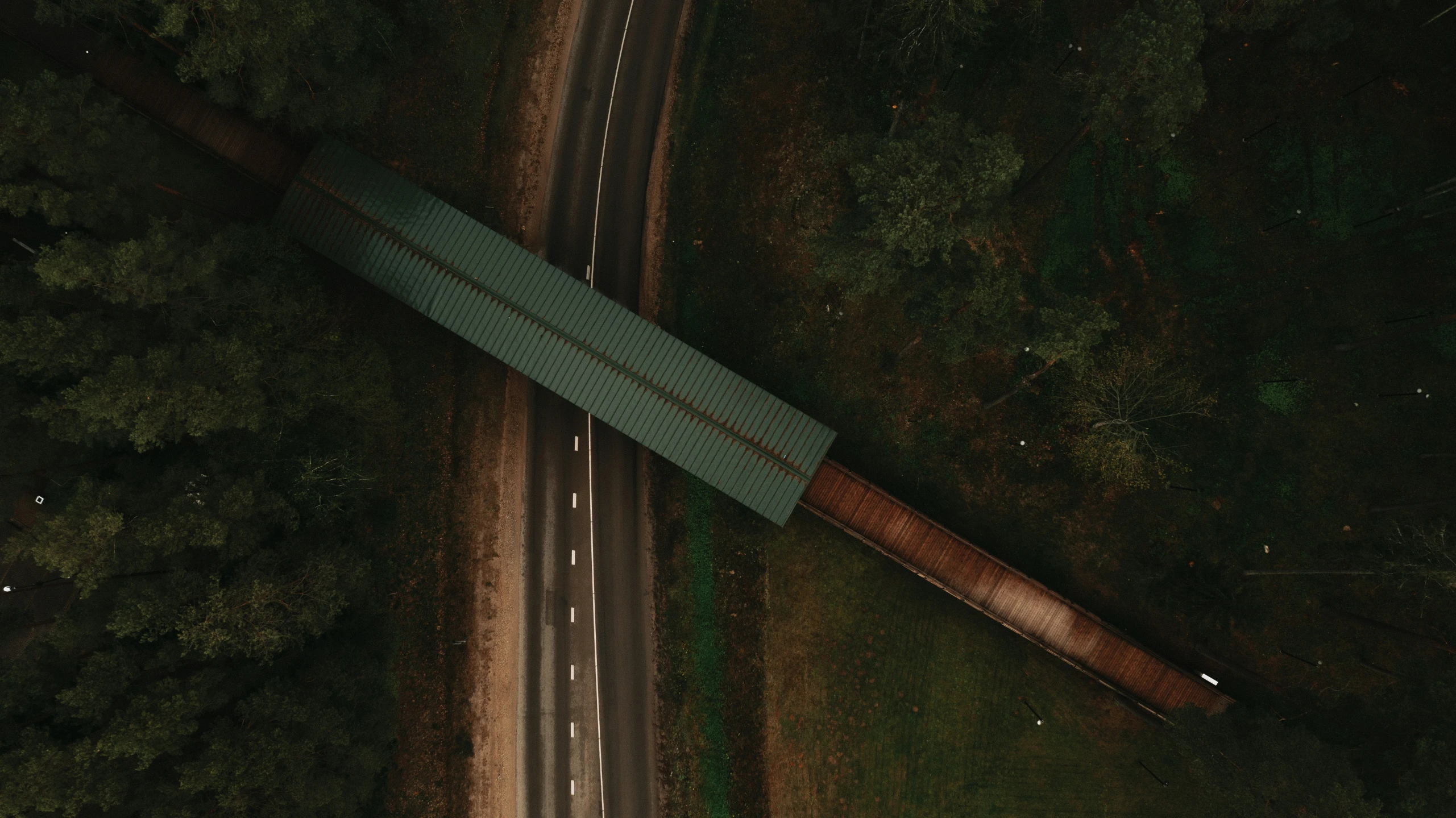 an aerial view of a highway and forest with trees