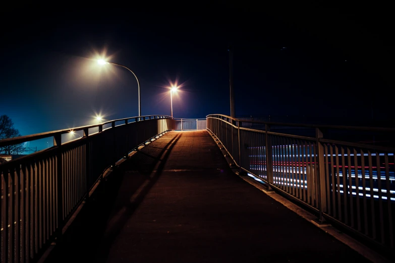 a lighted walkway in a city lit at night