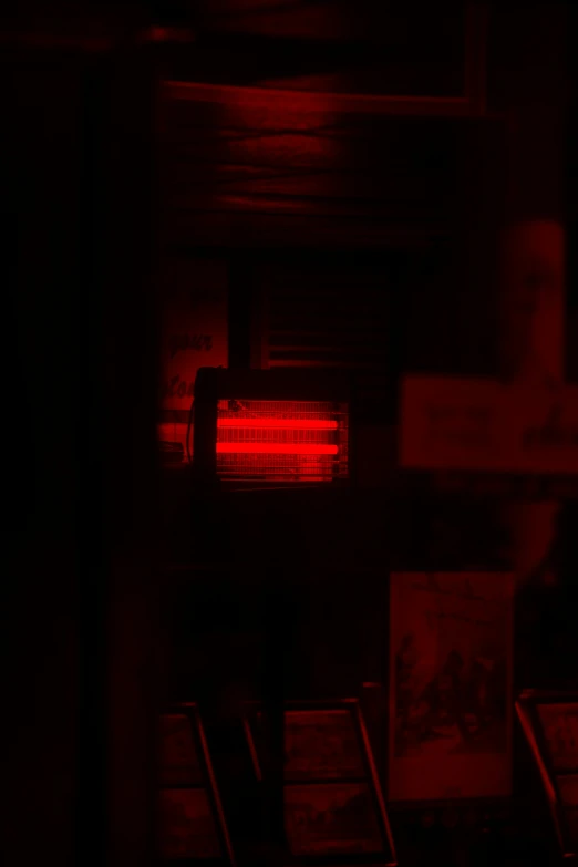 red sign hanging in the dark with other signs