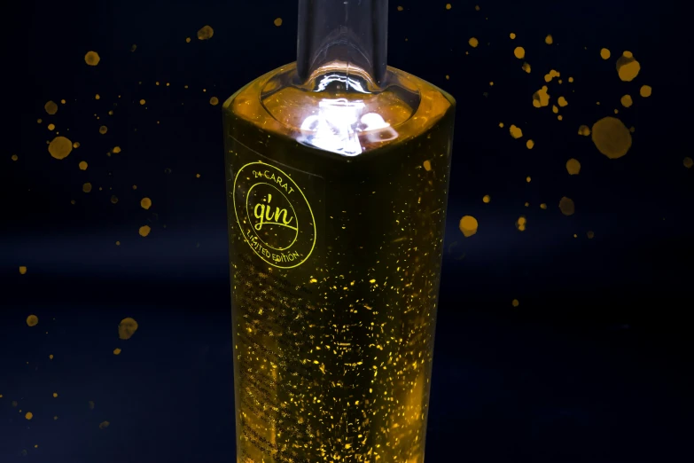 a yellow lighted liquor bottle sitting in the dark