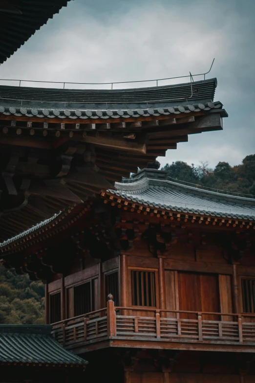 an old chinese house with a balcony surrounded by trees