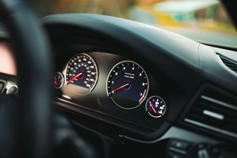 a car dashboard with some gauges showing red, white and blue