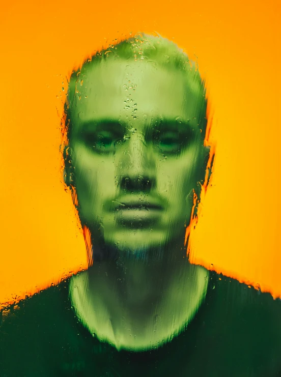a man that is green in color near an orange wall