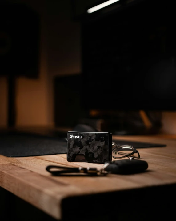 a computer, keychain and black case sitting on a table