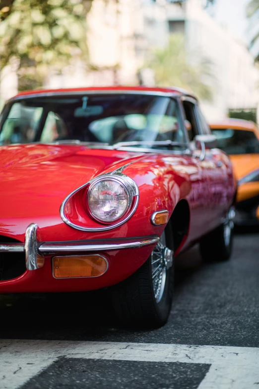 a couple of old red cars in front of each other