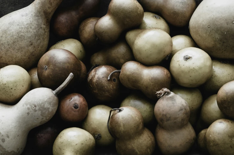 a pile of different kinds of pears and pomegranates