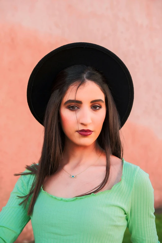 the young woman in the black hat is posing for the camera