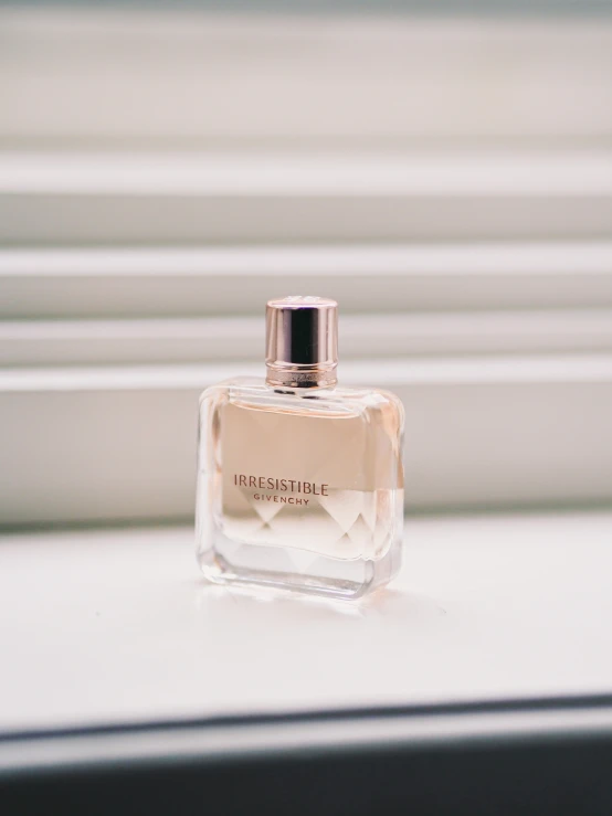 a bottle of perfume sitting on top of a white counter