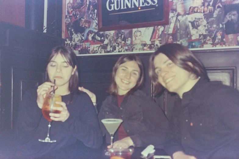 three young women enjoying drinks at a bar