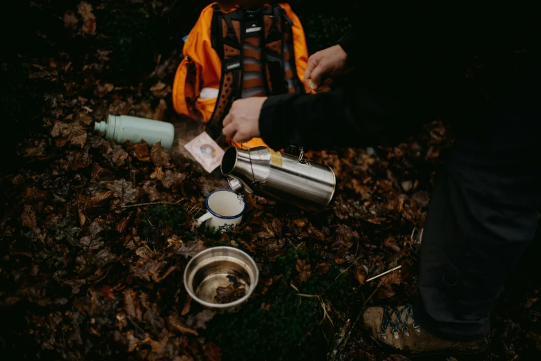 someone with a backpack and a small drink can sit in leaves