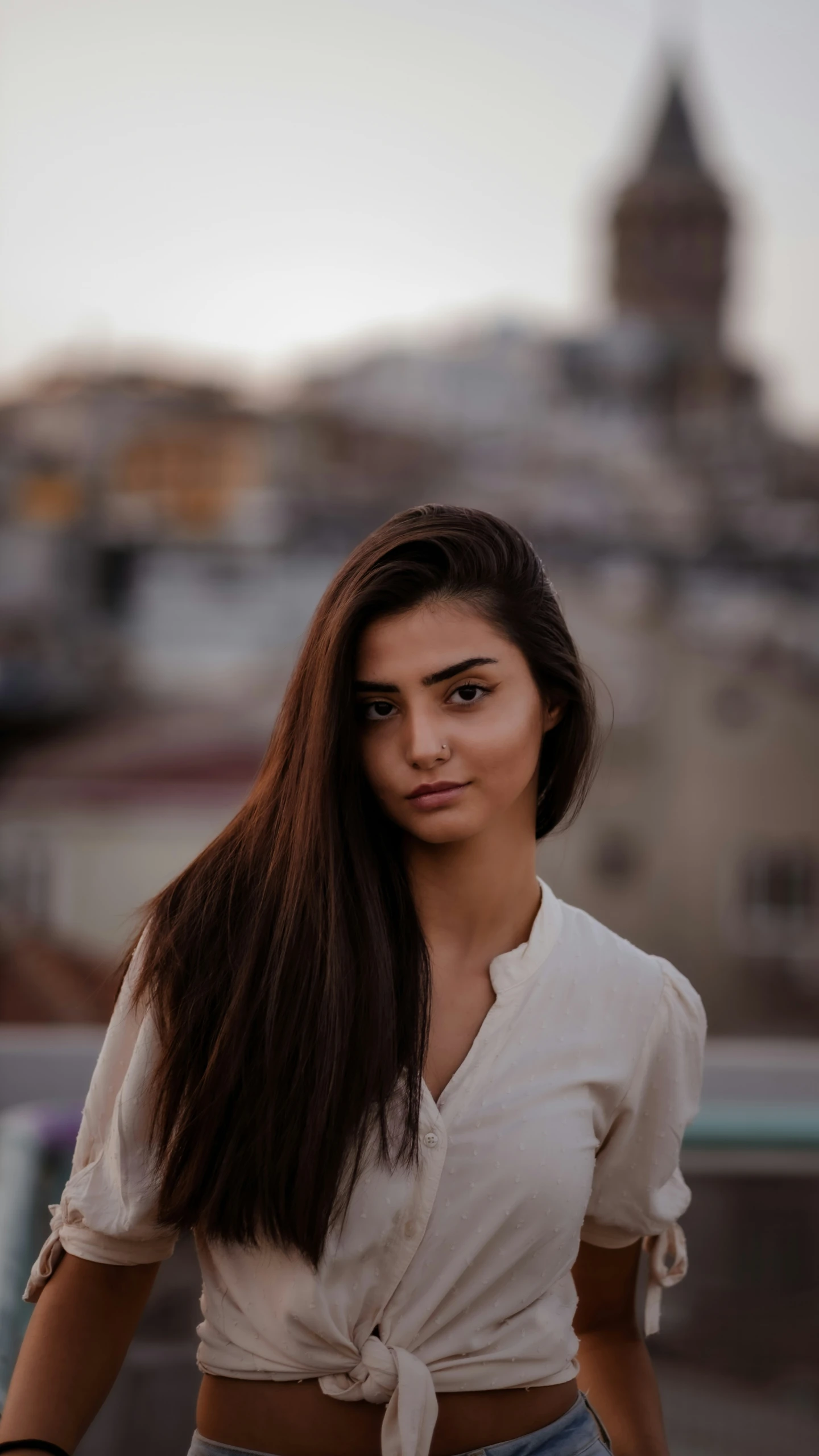 a woman is wearing a white top and jeans