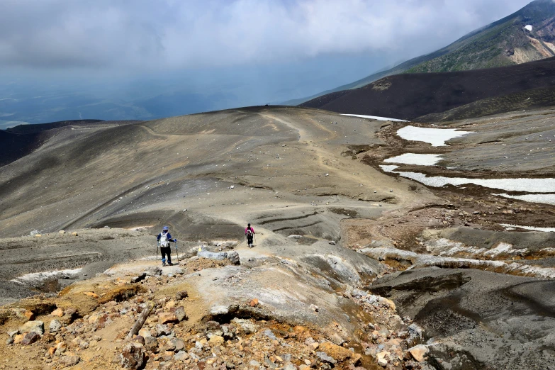 three men standing on a rock ledge in the mountains