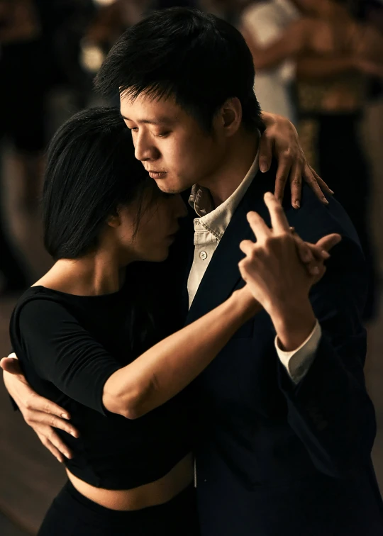 a man and woman hug each other while posing for a picture
