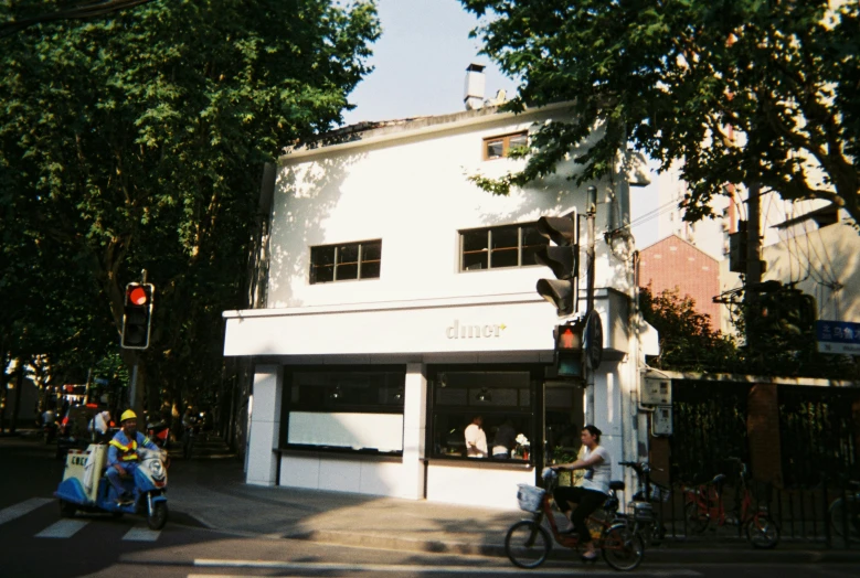 a building with people at the front and on bikes on the street