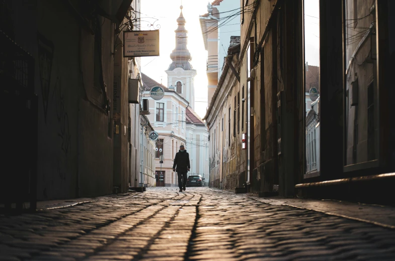 a street scene with focus on the shadow of people standing in front of buildings