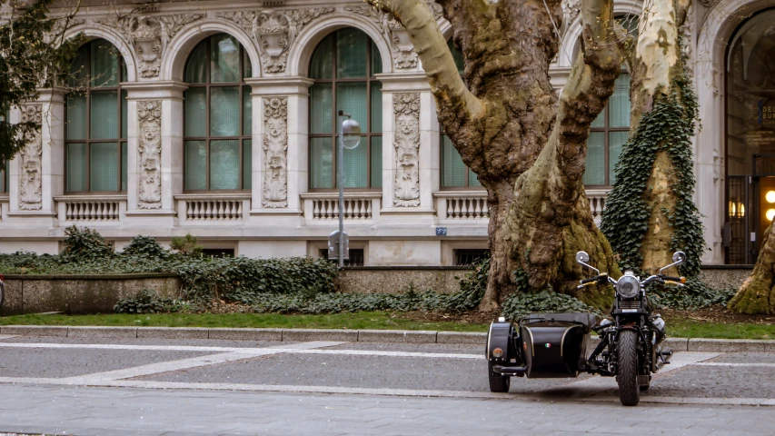 a motorcycle parked on the side of a road near a tree