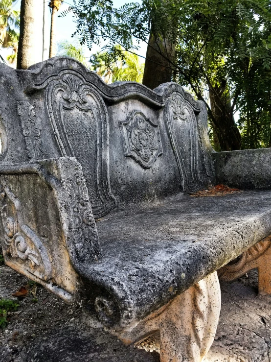 a bench sitting among many trees with carving on it