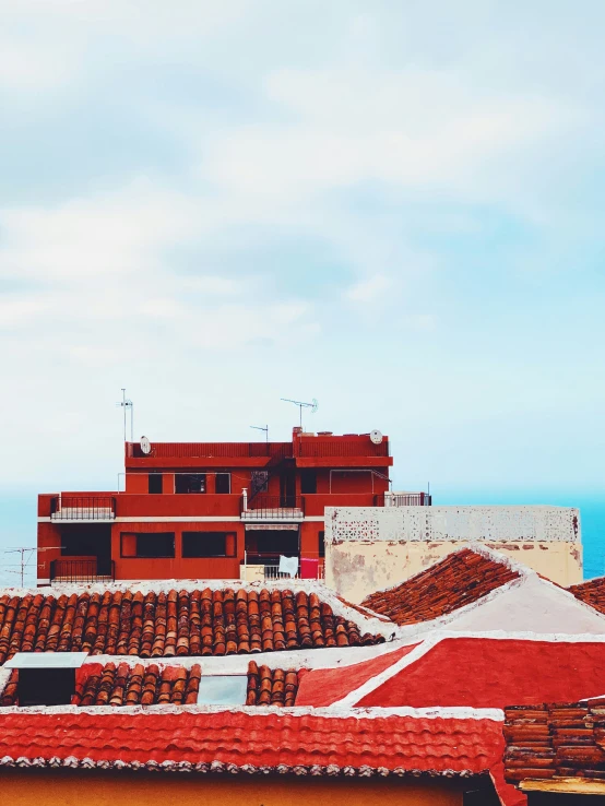 rooftop view of a building and sea with red tile roof