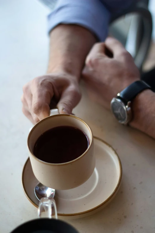 a close up of a persons hand holding a cup of coffee