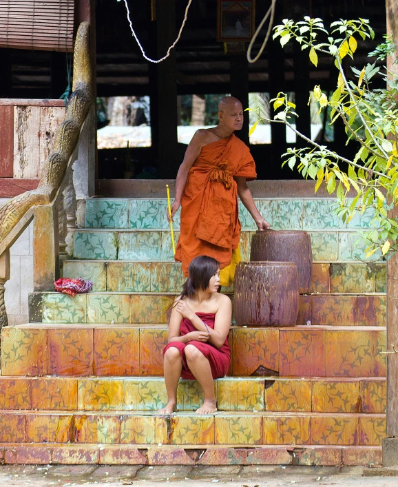 a man in a red robe stands on some steps