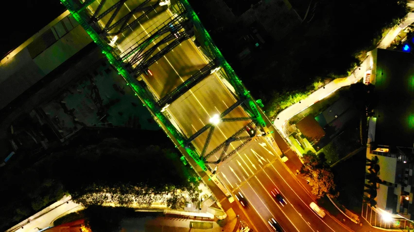 a city street and bridge are illuminated at night