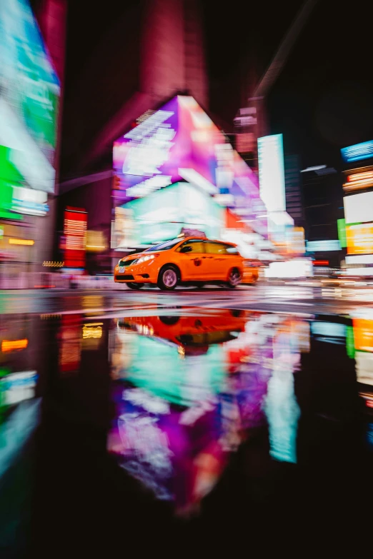 a yellow taxi driving on the street in the city