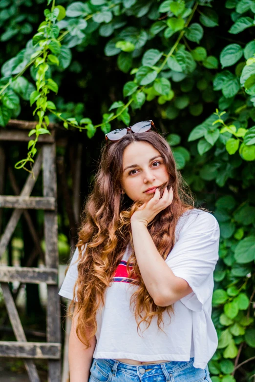 a  standing in front of a fence and leaves