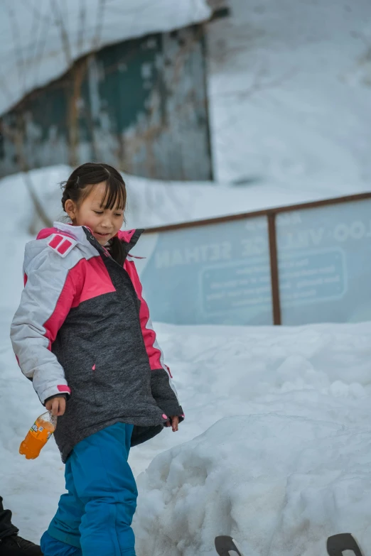 a little girl is standing on a pile of snow