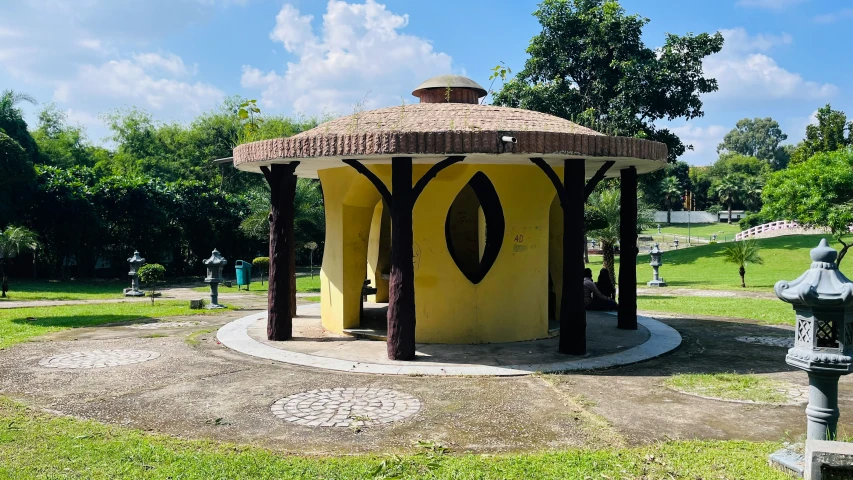 a small gazebo sits near a road in a park