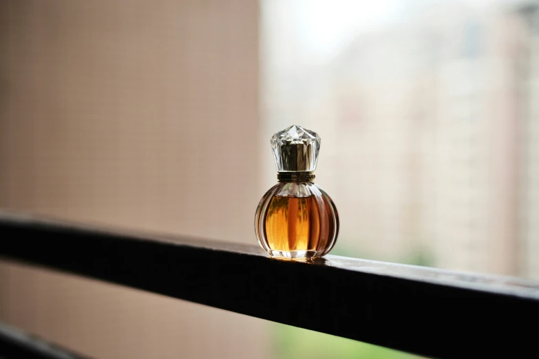 the top of an empty perfume bottle sitting on a rail