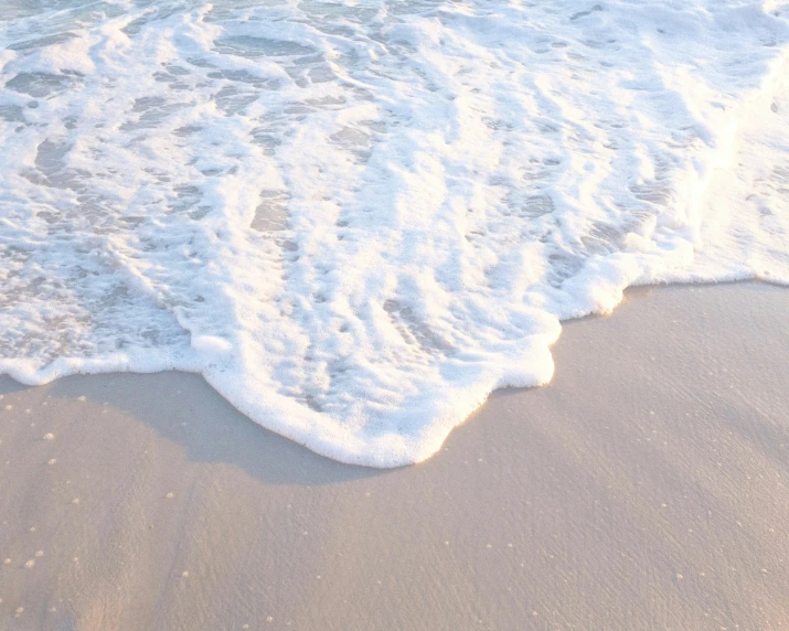 a surf board laying on the beach of a sandy shore