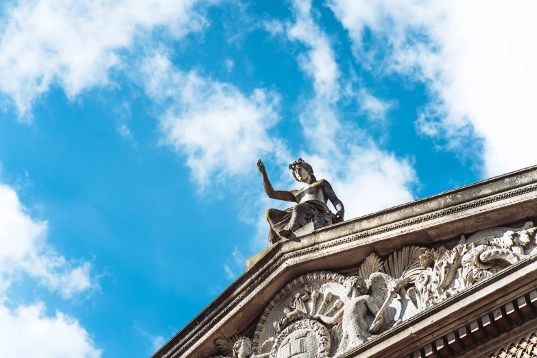 statue on roof with sky background and clouds