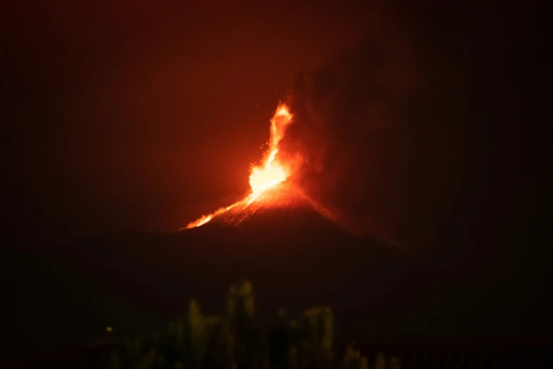 a large orange substance coming out of the top of a mountain