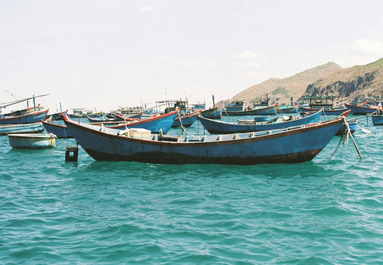 many blue boats floating on the water in a city