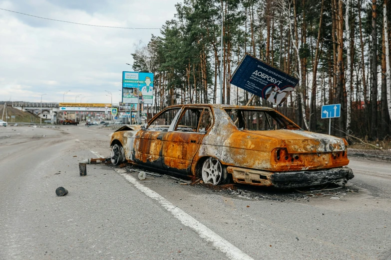 the rusted out cars on the side of the road