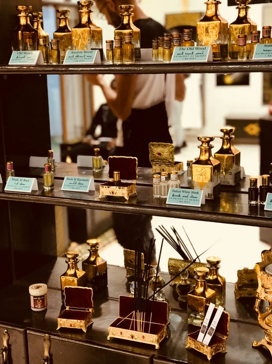 a display case in a perfume store filled with lots of golden colored items