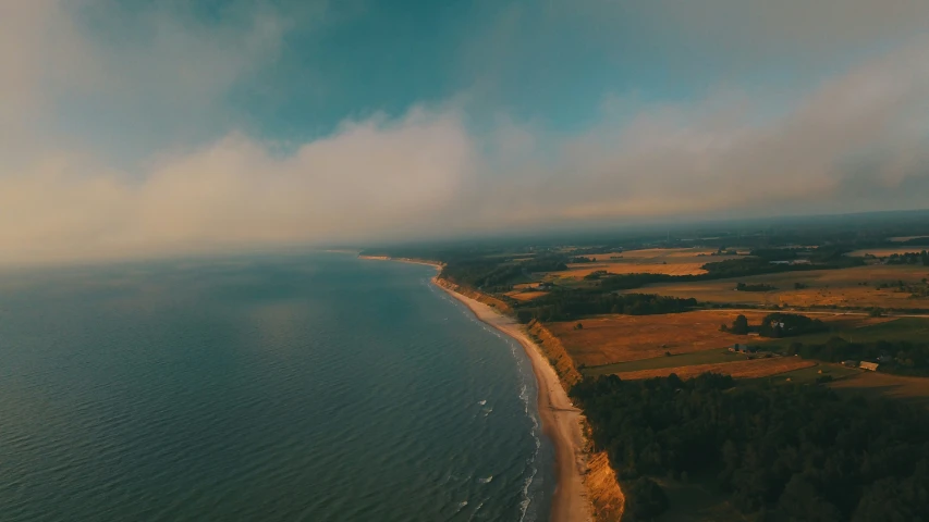 an ocean with a beach and grassy area next to the ocean