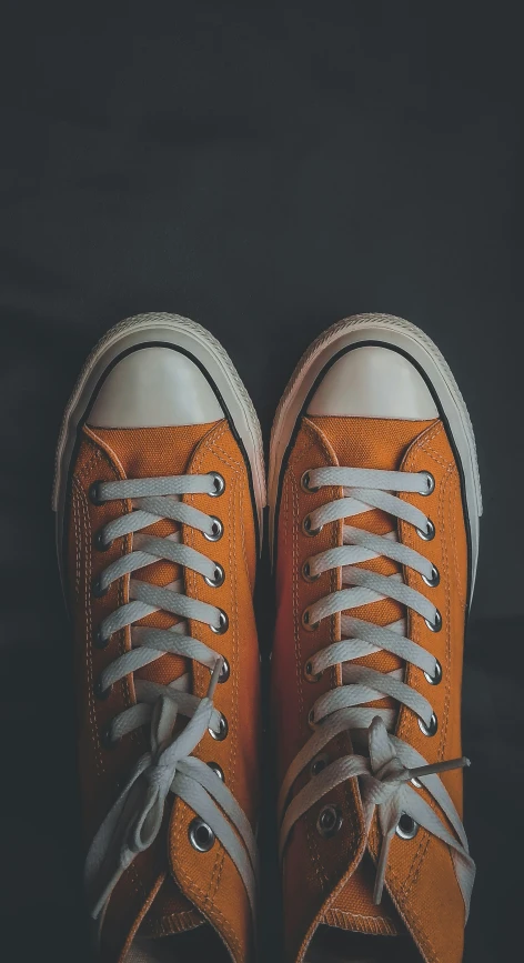 a pair of orange sneakers with grey laces